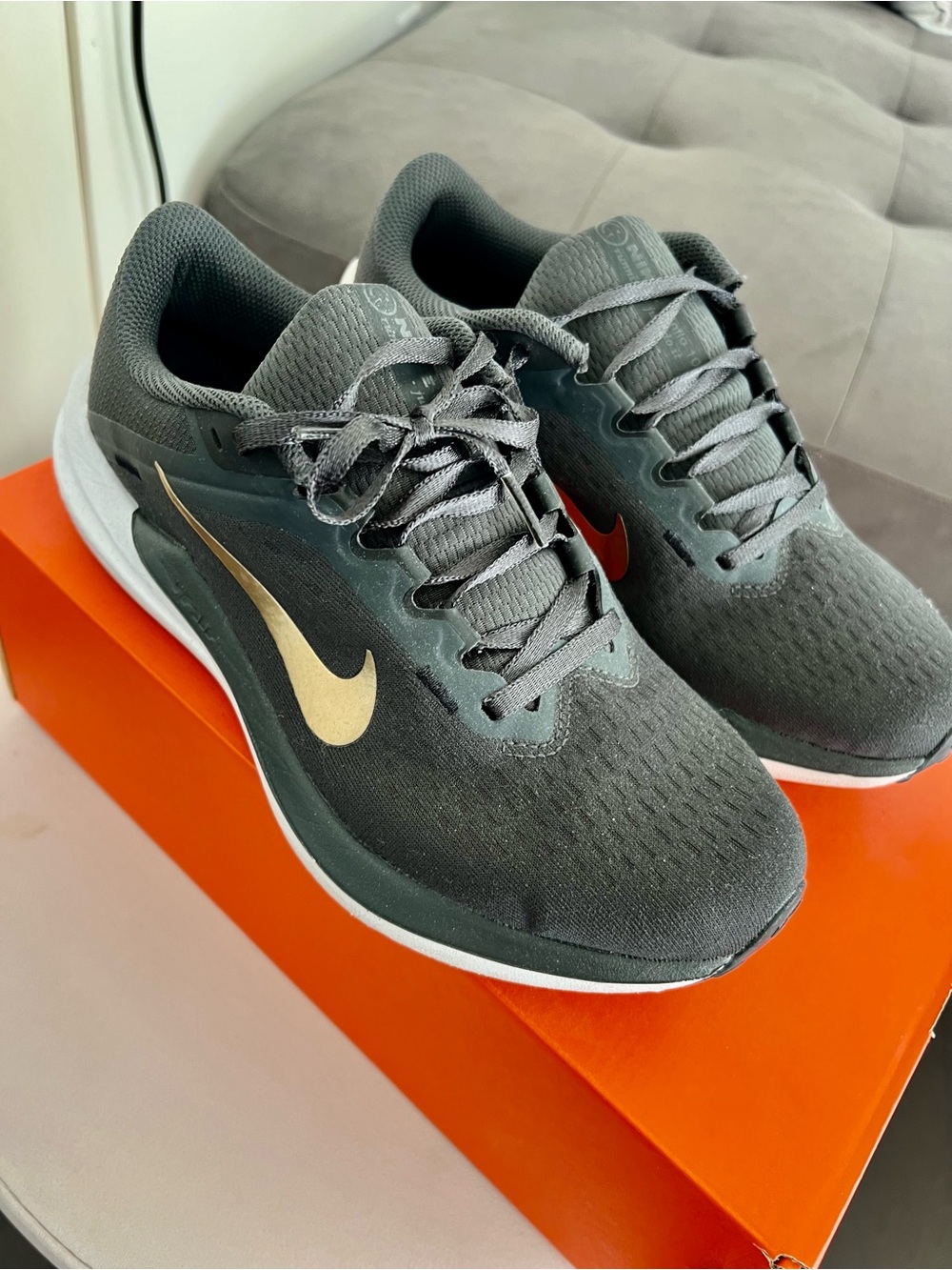 Nike women’s Dark Gray Athletic Running Shoes with Gold Swoosh